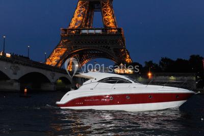 Bateau amarré le long d'un quai, avec une table dressée et des verres à vin sur le pont arrière.