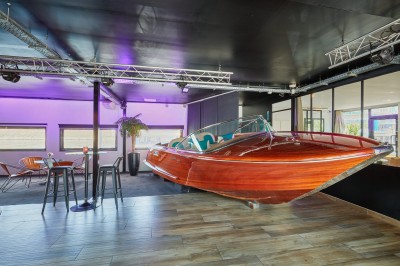 Bateau amarré le long d'un quai, avec une table dressée et des verres à vin sur le pont arrière.