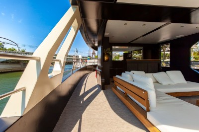 Bateau amarré le long d'un quai, avec une table dressée et des verres à vin sur le pont arrière.