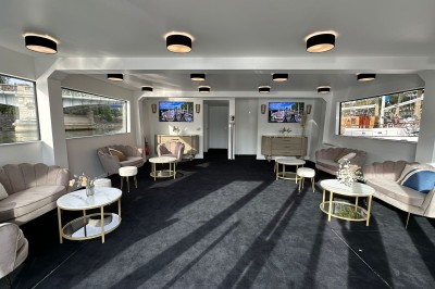 Bateau amarré le long d'un quai, avec une table dressée et des verres à vin sur le pont arrière.