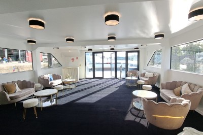 Bateau amarré le long d'un quai, avec une table dressée et des verres à vin sur le pont arrière.