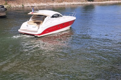 Bateau amarré le long d'un quai, avec une table dressée et des verres à vin sur le pont arrière.