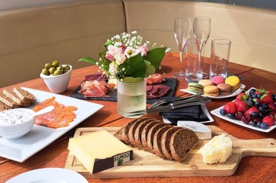 Bateau amarré le long d'un quai, avec une table dressée et des verres à vin sur le pont arrière.