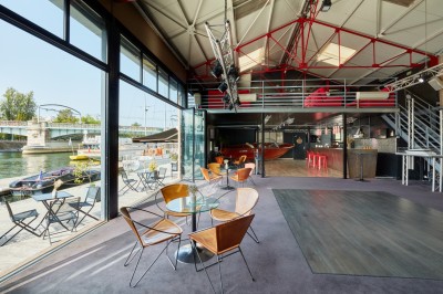 Miniature L'Atelier du France Bateau amarré le long d'un quai, avec une table dressée et des verres à vin sur le pont arrière.