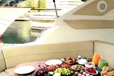Miniature Le James Bateau amarré le long d'un quai, avec une table dressée et des verres à vin sur le pont arrière.