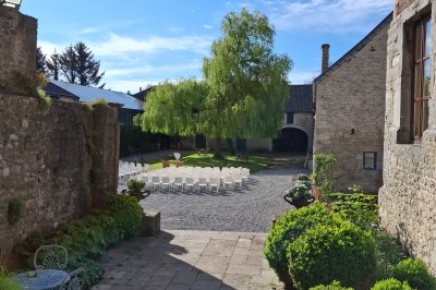 Salle décorée pour un repas festif avec longues tables dressées, guirlandes lumineuses et grand sapin illuminé.