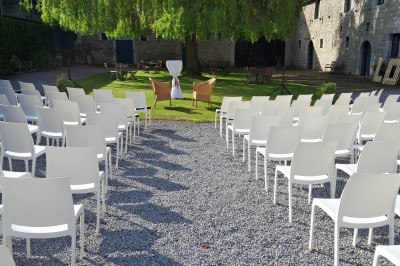 Salle décorée pour un repas festif avec longues tables dressées, guirlandes lumineuses et grand sapin illuminé.