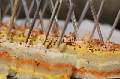 Mur en pierre ocre avec jardinières en bois garnies de fleurs colorées, entouré de végétation et éclairé par la lumière du…