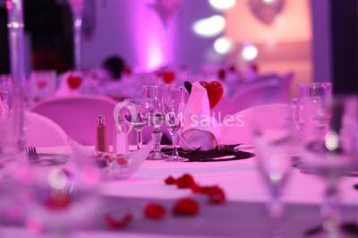 Mur en pierre ocre avec jardinières en bois garnies de fleurs colorées, entouré de végétation et éclairé par la lumière du…