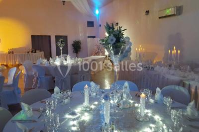Mur en pierre ocre avec jardinières en bois garnies de fleurs colorées, entouré de végétation et éclairé par la lumière du…
