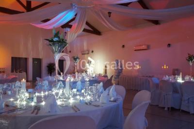 Mur en pierre ocre avec jardinières en bois garnies de fleurs colorées, entouré de végétation et éclairé par la lumière du…