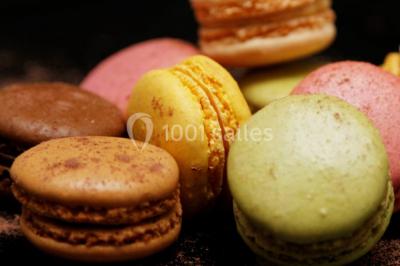 Mur en pierre ocre avec jardinières en bois garnies de fleurs colorées, entouré de végétation et éclairé par la lumière du…