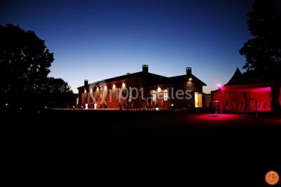 Miniature Location salle Alix (Rhône) - Domaine du Clos des Liesses #7 Chambre avec lit double, parquet clair, échelle en bois menant à une mezzanine, fenêtre avec rideaux et miroir debout.