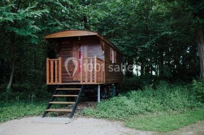 Miniature Location salle Alix (Rhône) - Domaine du Clos des Liesses #20 Chambre avec lit double, parquet clair, échelle en bois menant à une mezzanine, fenêtre avec rideaux et miroir debout.
