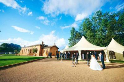 Miniature Location salle Alix (Rhône) - Domaine du Clos des Liesses #9 Chambre avec lit double, parquet clair, échelle en bois menant à une mezzanine, fenêtre avec rideaux et miroir debout.