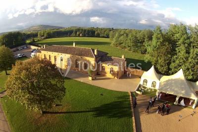 Miniature Location salle Alix (Rhône) - Domaine du Clos des Liesses #12 Chambre avec lit double, parquet clair, échelle en bois menant à une mezzanine, fenêtre avec rideaux et miroir debout.