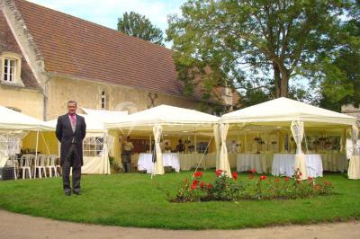 Salle à manger rustique avec murs en pierre, table en bois, chaises assorties et porte-fenêtre donnant sur l'extérieur.