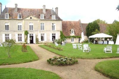Salle à manger rustique avec murs en pierre, table en bois, chaises assorties et porte-fenêtre donnant sur l'extérieur.