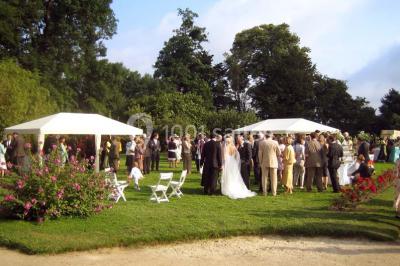 Salle à manger rustique avec murs en pierre, table en bois, chaises assorties et porte-fenêtre donnant sur l'extérieur.