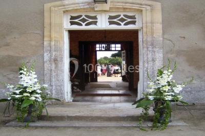 Salle à manger rustique avec murs en pierre, table en bois, chaises assorties et porte-fenêtre donnant sur l'extérieur.