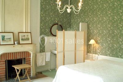 Salle à manger rustique avec murs en pierre, table en bois, chaises assorties et porte-fenêtre donnant sur l'extérieur.