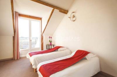 Filet de poisson servi sur un lit de légumes, garni de tomates séchées, herbes fraîches, et accompagné d'agrumes.