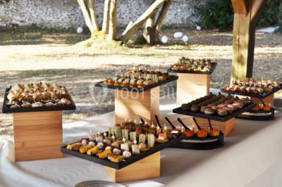 Filet de poisson servi sur un lit de légumes, garni de tomates séchées, herbes fraîches, et accompagné d'agrumes.