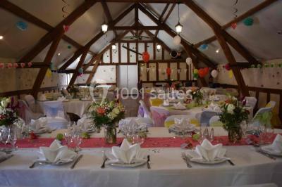 Filet de poisson servi sur un lit de légumes, garni de tomates séchées, herbes fraîches, et accompagné d'agrumes.
