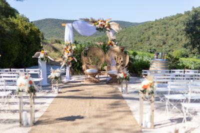 Vue d'un bâtiment moderne avec une structure blanche entouré de végétation méditerranéenne et d'un ciel bleu clair.