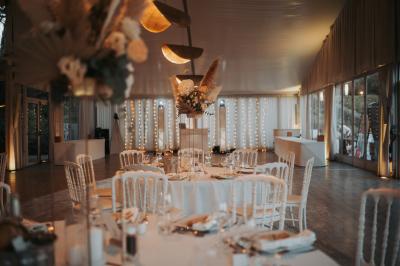 Vue d'un bâtiment moderne avec une structure blanche entouré de végétation méditerranéenne et d'un ciel bleu clair.
