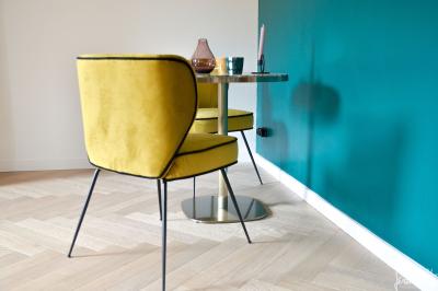 Vue d'un bâtiment moderne avec une structure blanche entouré de végétation méditerranéenne et d'un ciel bleu clair.