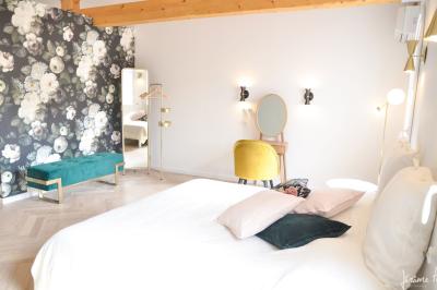 Vue d'un bâtiment moderne avec une structure blanche entouré de végétation méditerranéenne et d'un ciel bleu clair.