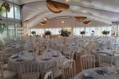 Vue d'un bâtiment moderne avec une structure blanche entouré de végétation méditerranéenne et d'un ciel bleu clair.