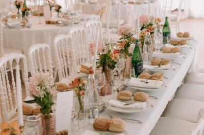 Vue d'un bâtiment moderne avec une structure blanche entouré de végétation méditerranéenne et d'un ciel bleu clair.