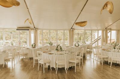 Vue d'un bâtiment moderne avec une structure blanche entouré de végétation méditerranéenne et d'un ciel bleu clair.
