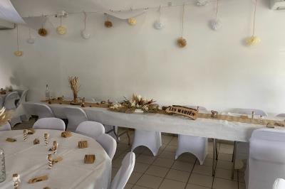 Cuisine professionnelle avec équipements en inox, comprenant un réfrigérateur, une hotte, un four et des plans de travail.