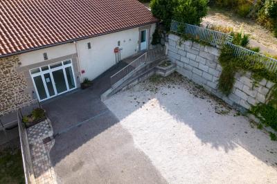 Cuisine professionnelle avec équipements en inox, comprenant un réfrigérateur, une hotte, un four et des plans de travail.