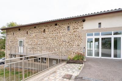 Cuisine professionnelle avec équipements en inox, comprenant un réfrigérateur, une hotte, un four et des plans de travail.