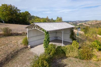 Cuisine professionnelle avec équipements en inox, comprenant un réfrigérateur, une hotte, un four et des plans de travail.
