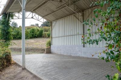 Cuisine professionnelle avec équipements en inox, comprenant un réfrigérateur, une hotte, un four et des plans de travail.