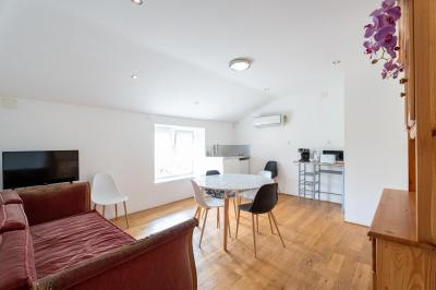 Cuisine professionnelle avec équipements en inox, comprenant un réfrigérateur, une hotte, un four et des plans de travail.