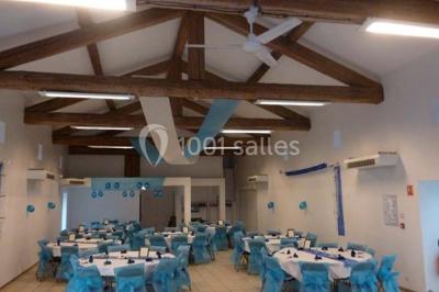 Cuisine professionnelle avec équipements en inox, comprenant un réfrigérateur, une hotte, un four et des plans de travail.