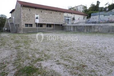 Cuisine professionnelle avec équipements en inox, comprenant un réfrigérateur, une hotte, un four et des plans de travail.