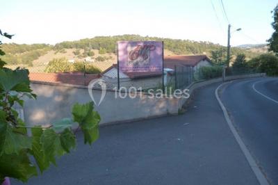 Cuisine professionnelle avec équipements en inox, comprenant un réfrigérateur, une hotte, un four et des plans de travail.