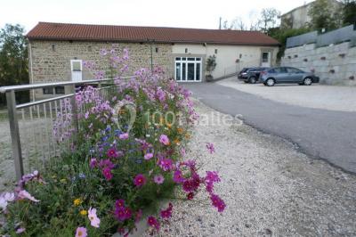 Cuisine professionnelle avec équipements en inox, comprenant un réfrigérateur, une hotte, un four et des plans de travail.
