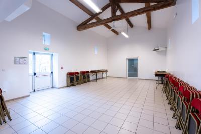 Cuisine professionnelle avec équipements en inox, comprenant un réfrigérateur, une hotte, un four et des plans de travail.