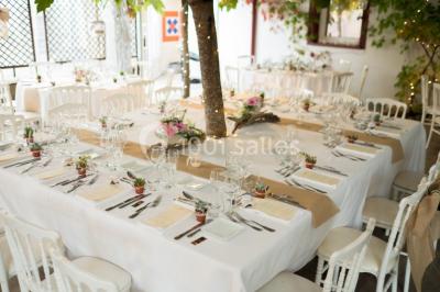 Groupe de personnes discutant sur une terrasse éclairée, entourée de végétation et de bougies.