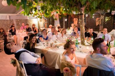 Groupe de personnes discutant sur une terrasse éclairée, entourée de végétation et de bougies.