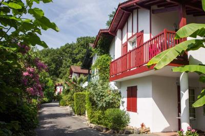 Groupe de personnes discutant sur une terrasse éclairée, entourée de végétation et de bougies.
