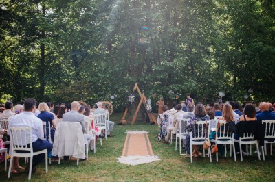 Groupe de personnes discutant sur une terrasse éclairée, entourée de végétation et de bougies.